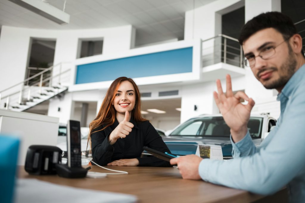 Car showroom client and salesman show ok gestures